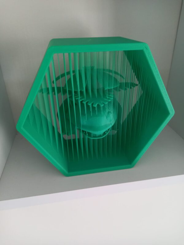 Vista lateral de figura impresa en 3D con efecto de suspensión mediante hilos