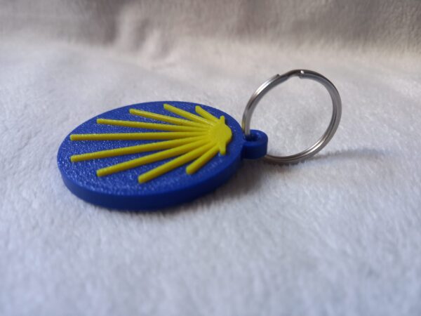 Llavero circular del Camino de Santiago con concha amarilla en relieve sobre fondo azul