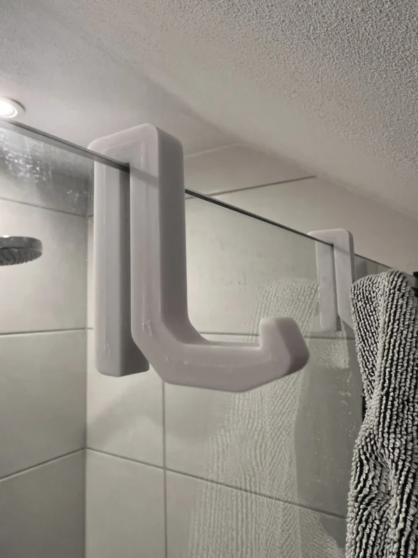 Gancho práctico y moderno colgado en mampara de baño, ideal para accesorios